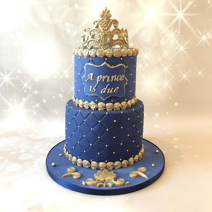 a three tiered blue cake with gold decorations