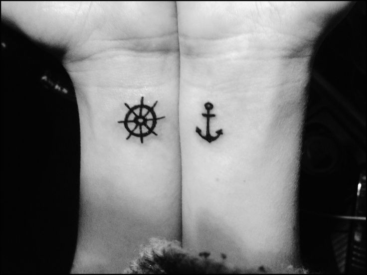 two people with matching tattoos on their wrists, one has an anchor and the other has a ship wheel