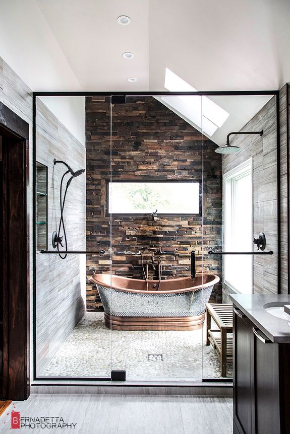 an instagramted photo of a bathroom with a stone wall and bathtub in the middle