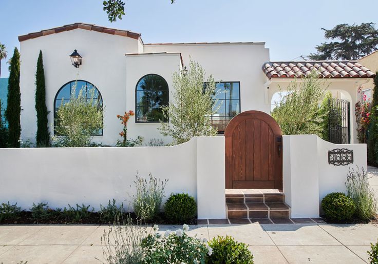 a white house with an arched wooden door