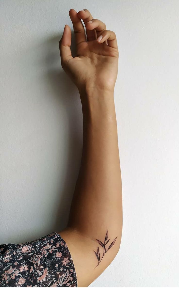 a woman's arm with a small tattoo on the left side of her arm