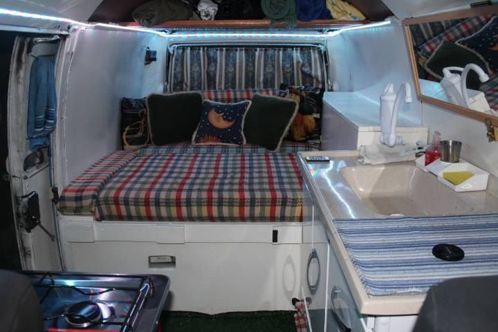 the inside of a camper with a bed and sink