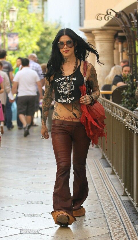 a woman with tattoos walking down the street