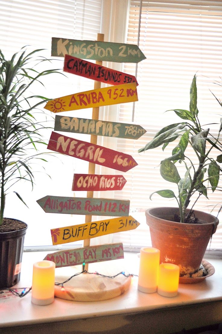 a wooden sign sitting on top of a table next to a potted plant