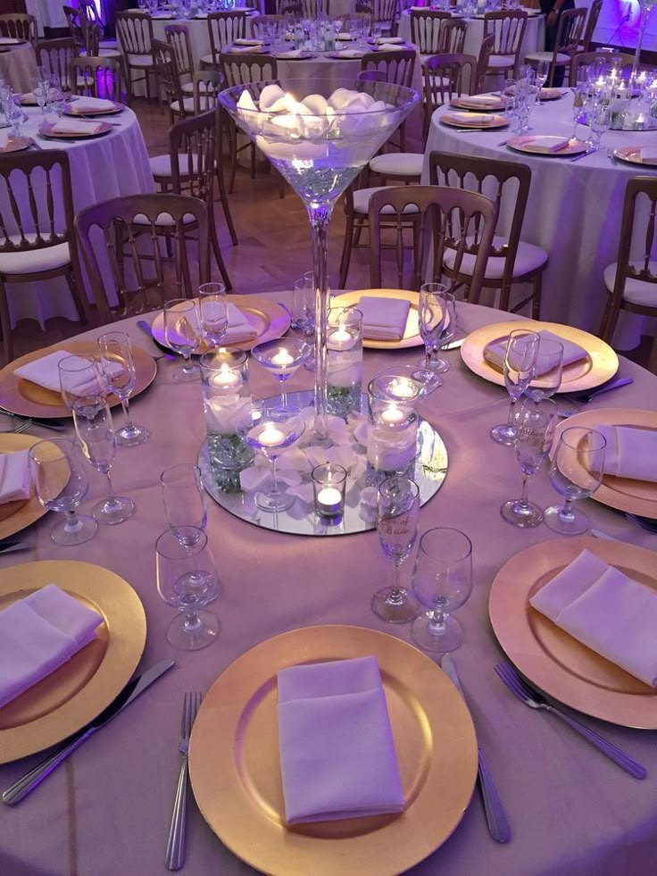 the table is set with plates, silverware and purple linens for an elegant dinner