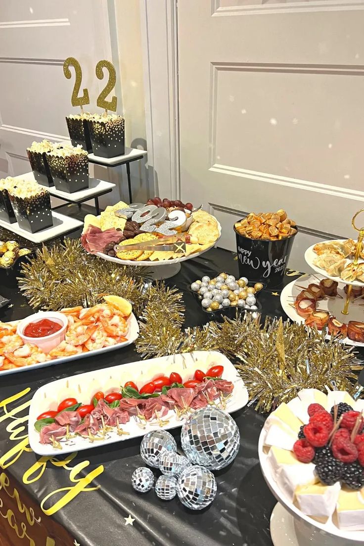 a table topped with lots of food and desserts next to a white door covered in confetti