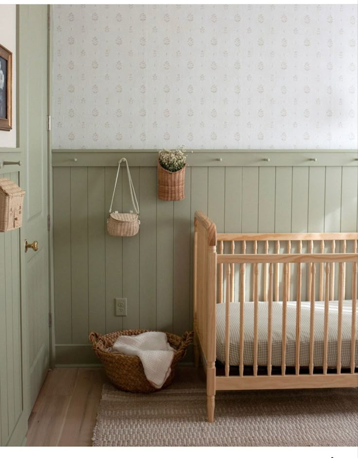 a baby's room with a crib and basket hanging on the wall