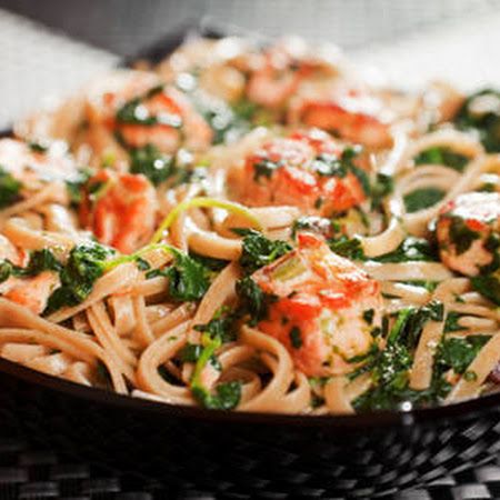 pasta with shrimp and spinach in a black bowl