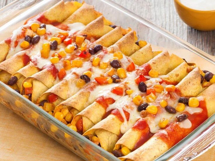 a casserole dish filled with corn, black beans, cheese and tortilla bread