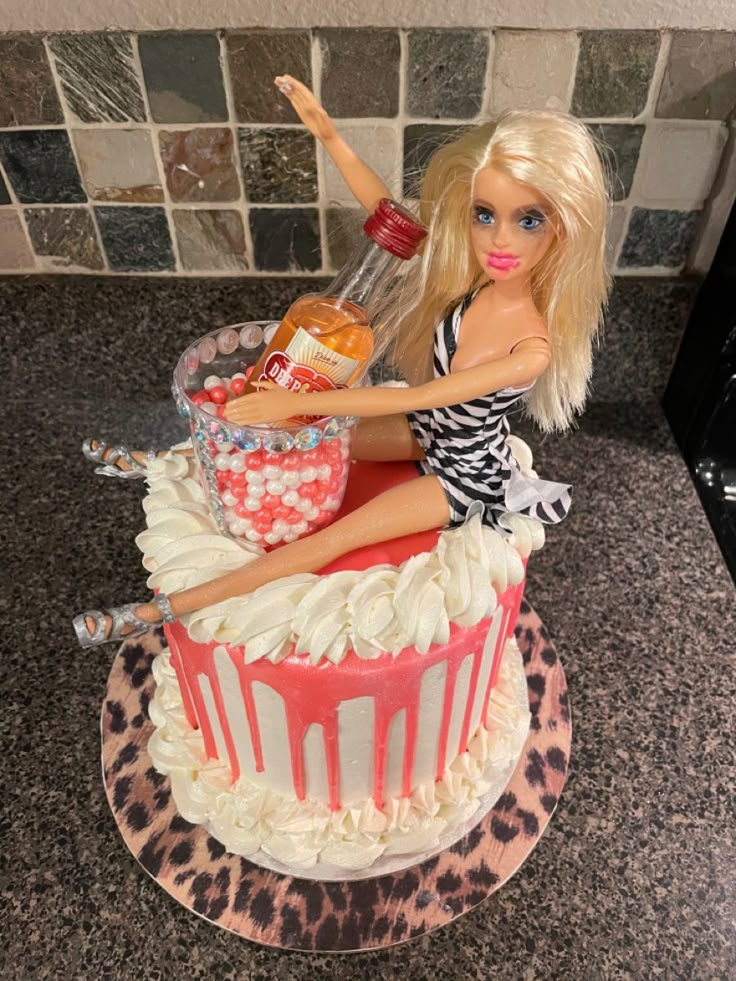 a barbie doll sitting on top of a cake