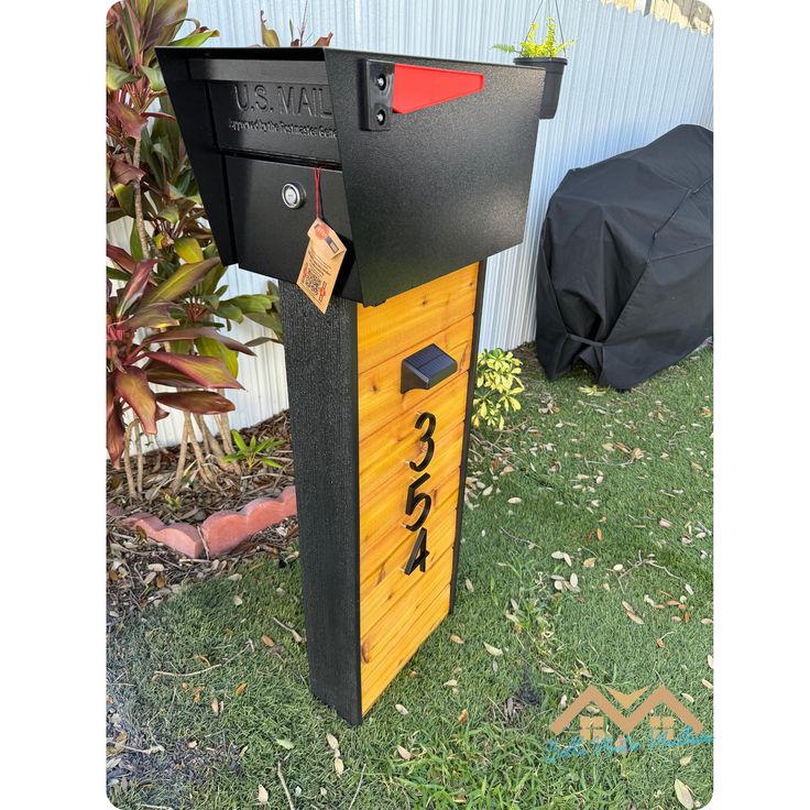 a mailbox sitting in the grass next to a building