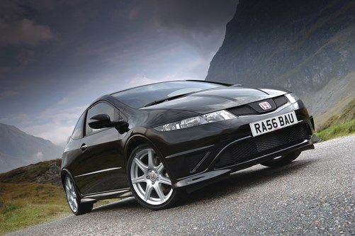 a black sports car parked on the side of a mountain road