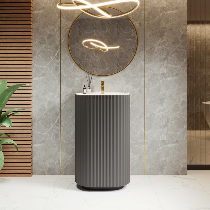 a modern bathroom with a round mirror and marble counter top, along with a plant in the corner