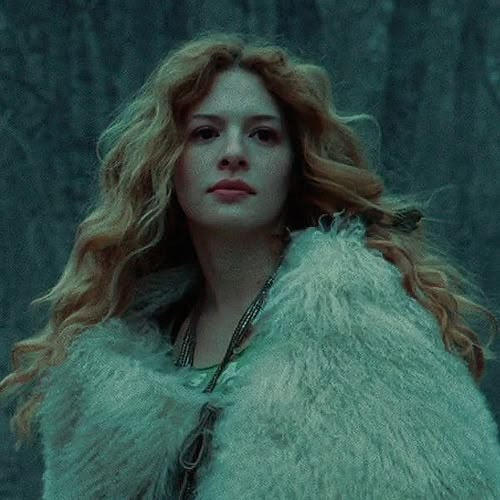 a woman with long red hair wearing a fur coat