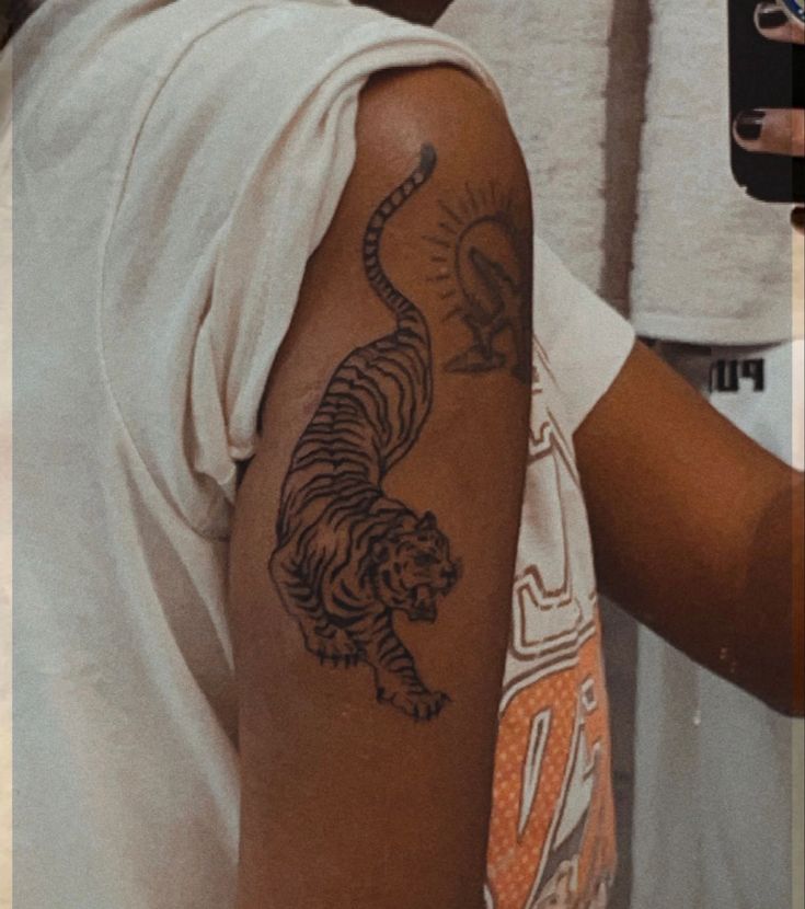 a man with a tiger tattoo on his arm