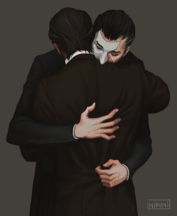 two people hugging each other with their arms around one another, both wearing black and white masks