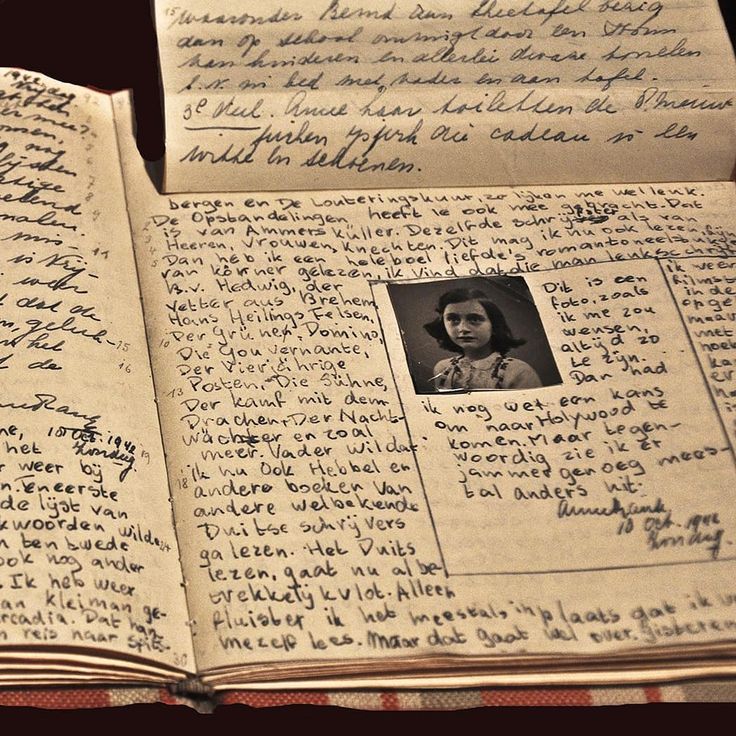 an open book with writing on it and a photo in the middle, sitting on top of a checkered table cloth