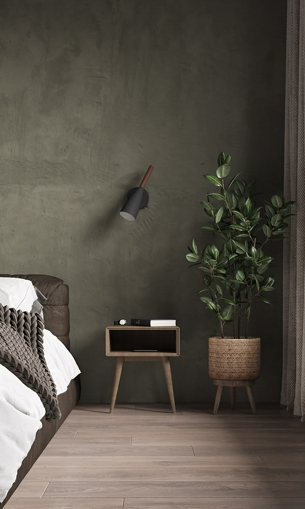 a bedroom with dark green walls and white bedding, potted plant next to the bed