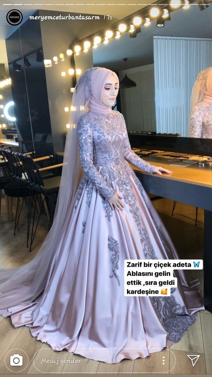 an image of a woman in a muslim wedding dress looking at herself in the mirror