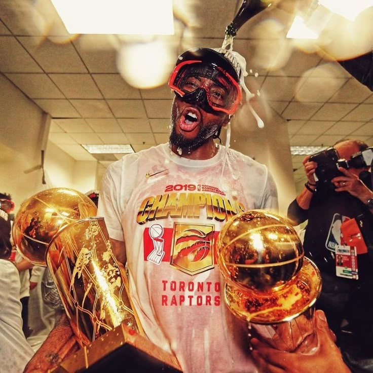 a man holding three golden basketballs in his hands and wearing goggles on his head