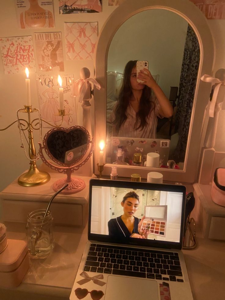 a laptop computer sitting on top of a desk next to a vanity with a mirror