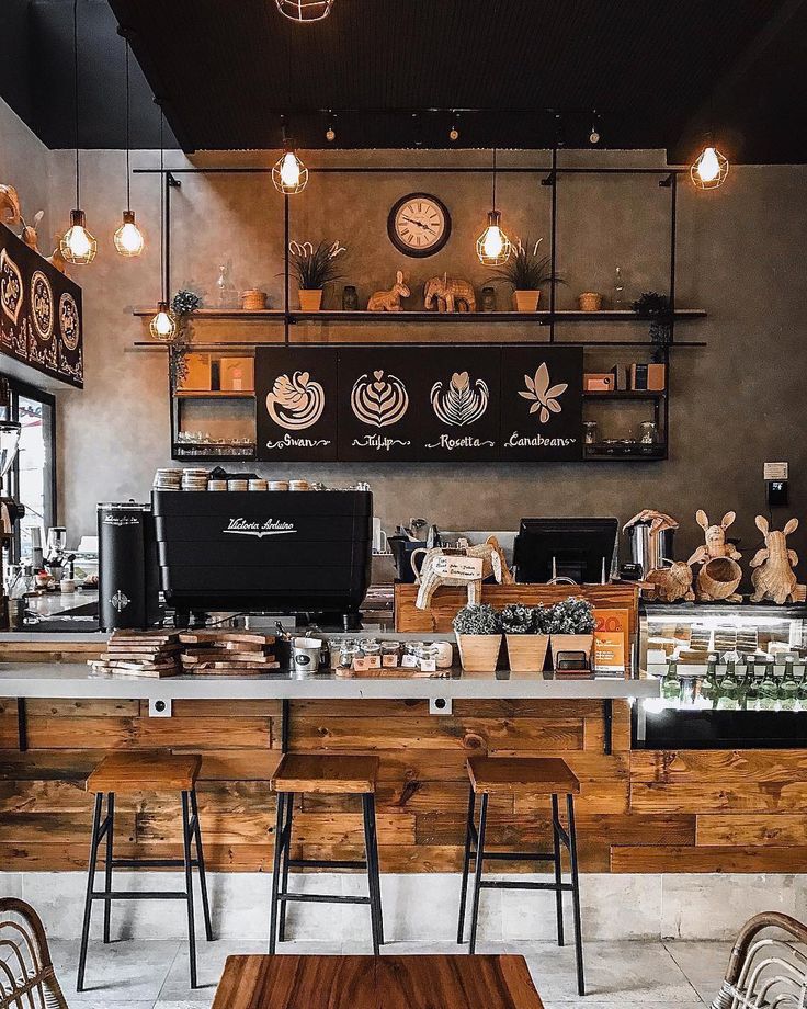 the interior of a coffee shop with wooden tables and chairs