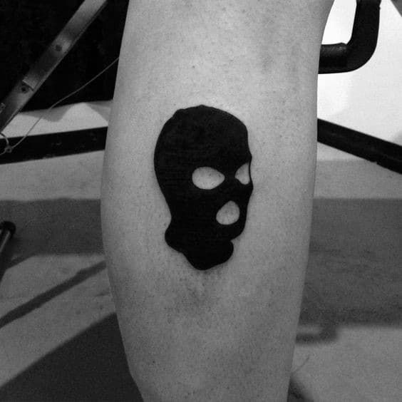 a black and white photo of a person's leg with a skull tattoo on it