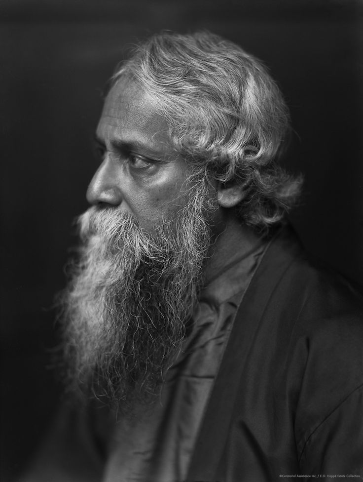 an old black and white photo of a man with a long, gray beard wearing a shirt