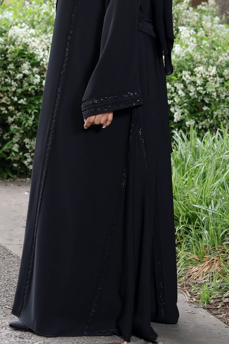 Meet your new dressy bestie, Anhaar. Made from buttery-soft Nida fabric, its A-line cut offers a flattering silhouette. Whether you're attending a special occasion or simply want to elevate your everyday look, Anhaar promises to be your go-to choice, blending comfort, style, and elegance seamlessly. Made with silk Nida Open abaya with hidden buttons Shayla (Hijab) included Model is 5'5 and is wearing size 56 Made in Dubai Black Abaya Designs Simple, Shayla Hijab, Elegant Abayas, Black Abaya Designs, Dresses Hijab, Black Abaya, Open Abaya, A Line Cut, Abaya Designs