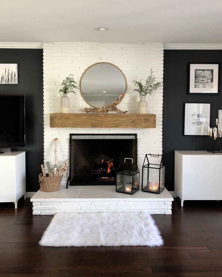 a living room with a fire place and white brick fireplace in the center, surrounded by pictures on the wall