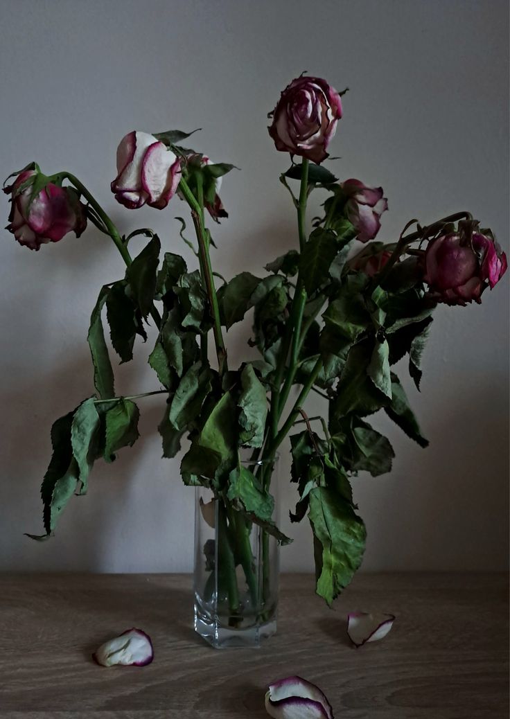 a vase filled with pink flowers on top of a wooden table