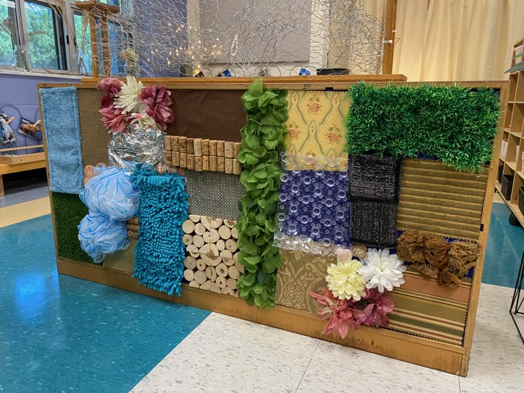 a display case with many different types of fabric and flowers on it in a store