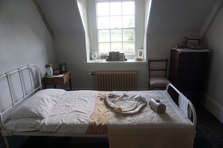 a bedroom with a bed, dresser and window