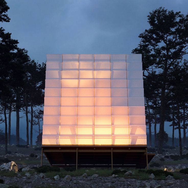 an illuminated structure in the middle of a forest