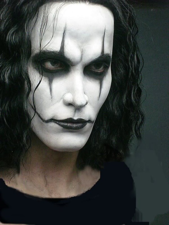 a close up of a person with makeup on their face and dark hair wearing a white mask