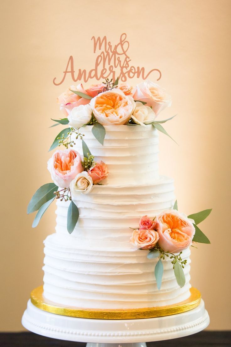 a white wedding cake with flowers on top