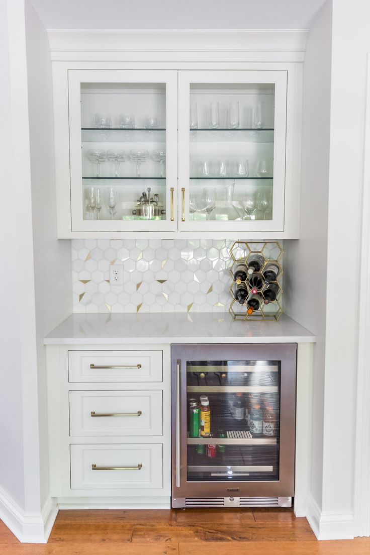 a kitchen with white cabinets and glass front cupboards in the center, along with a stainless steel stove top oven