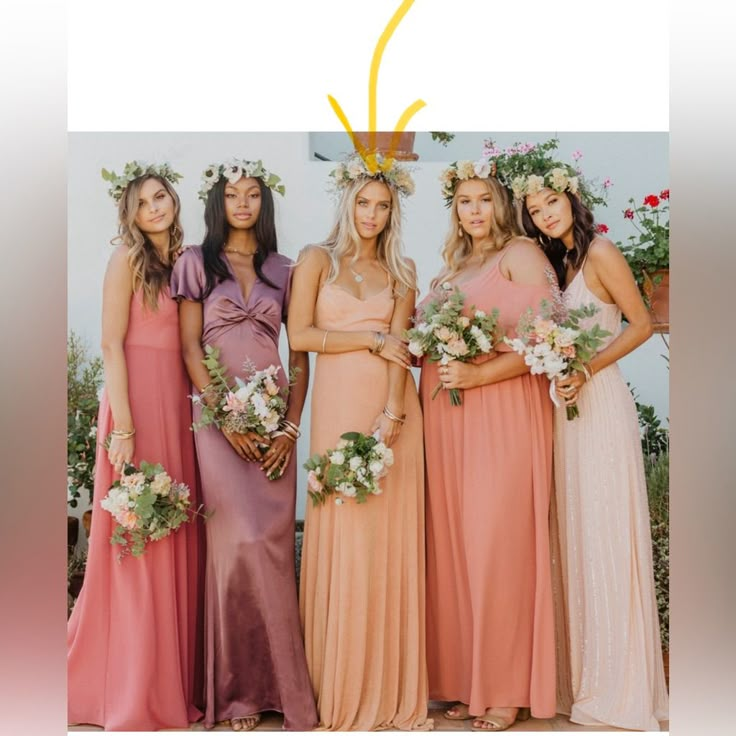 a group of women standing next to each other wearing dresses and holding flowers in their hair