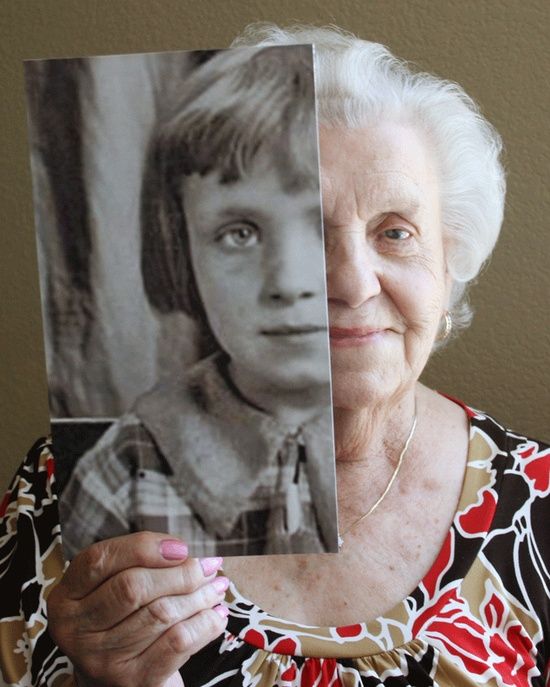 an older woman holding up a photo with her face