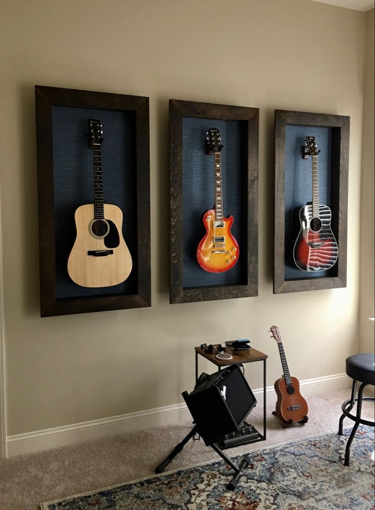 three guitars are hanging on the wall in a living room