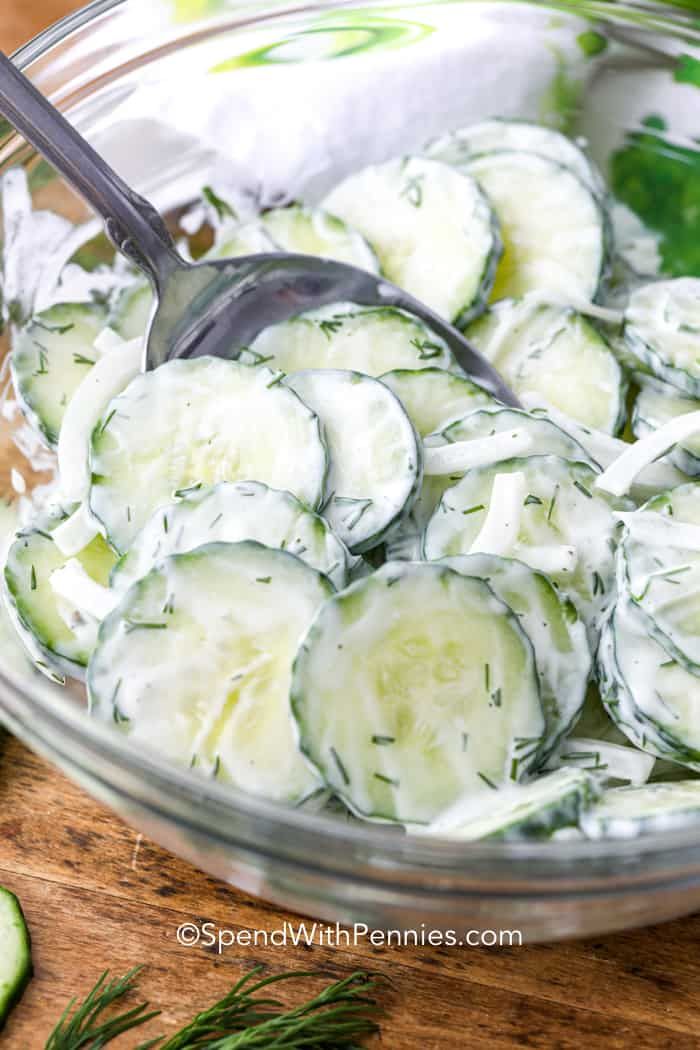 cucumber salad in a glass bowl with a spoon