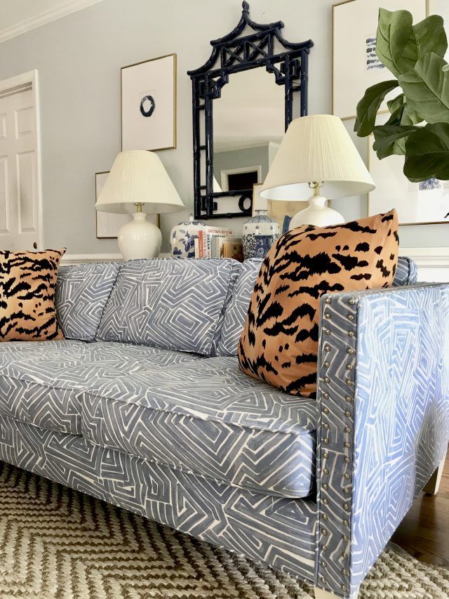 a living room filled with furniture and two lamps on top of each other in front of a mirror