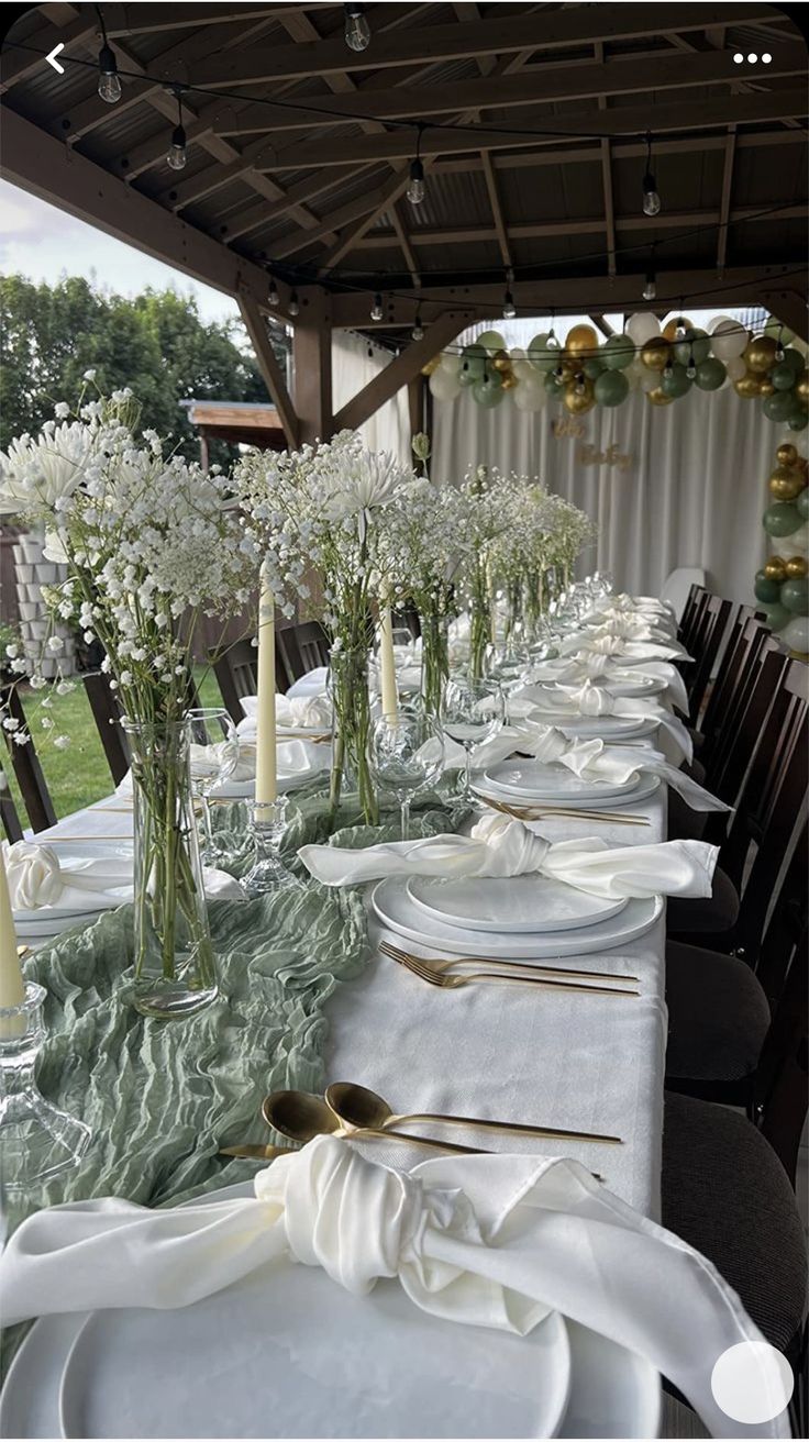 a long table is set with white plates and silverware