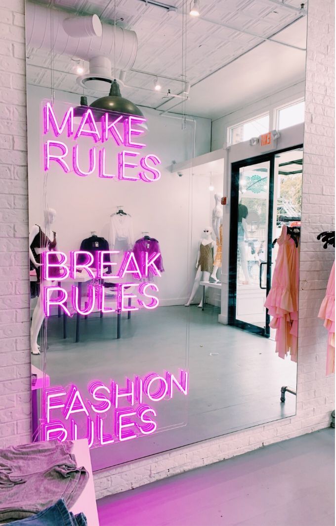 a pink neon sign that says make rules break rules fashion rules