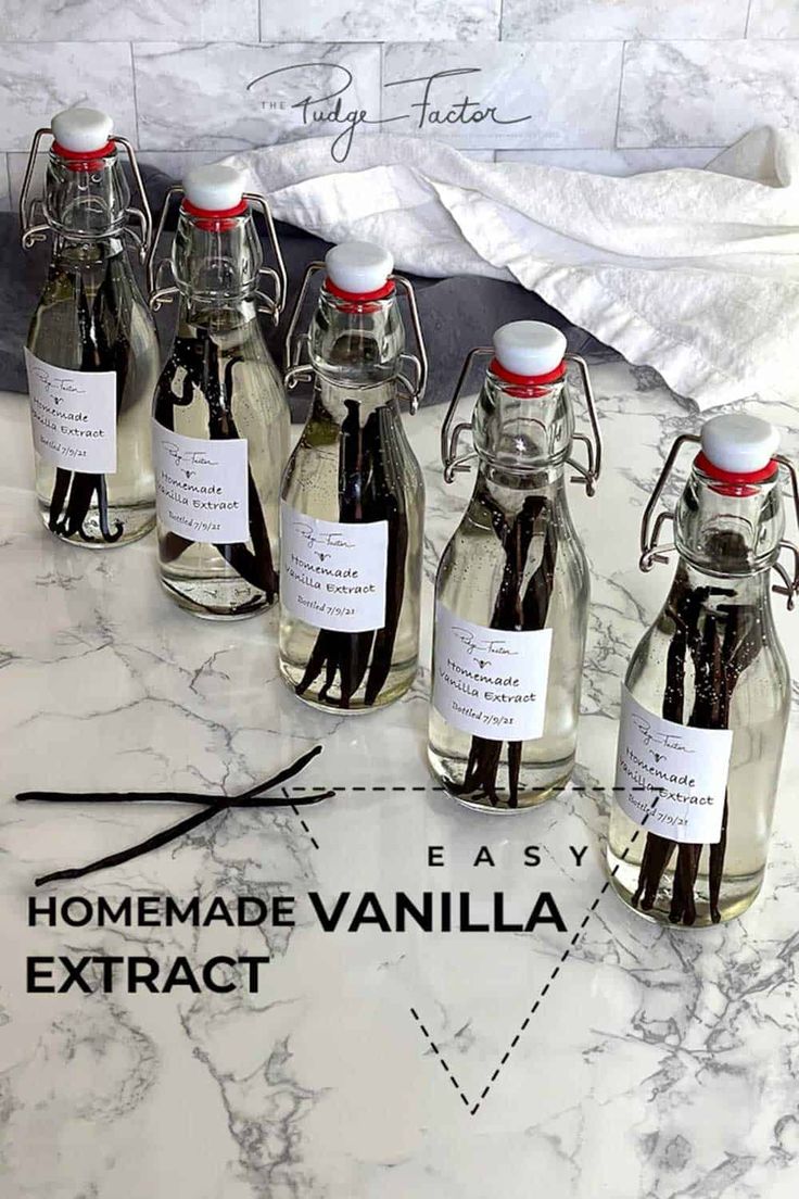 six bottles of homemade vanilla syrup on a marble counter top with labels for each bottle