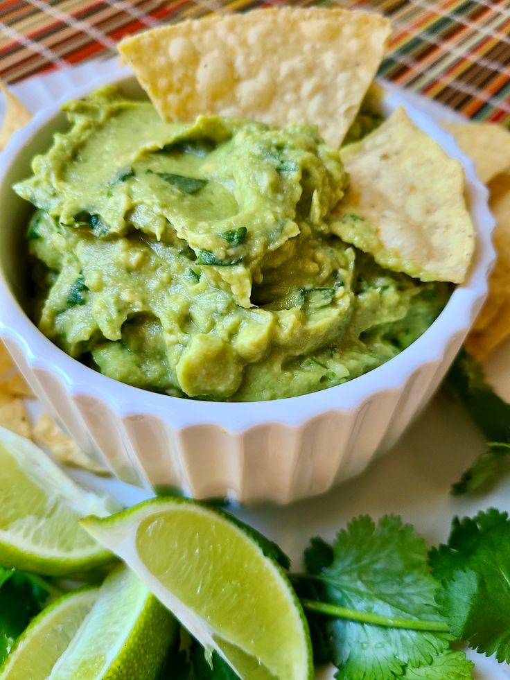 guacamole in a bowl with tortilla chips on the side