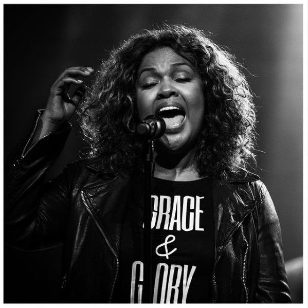 a woman singing into a microphone on stage