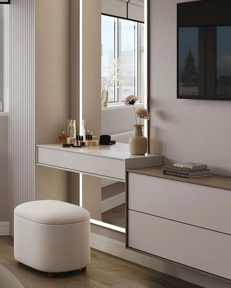 a white vanity with a mirror and stool in a room next to a large window