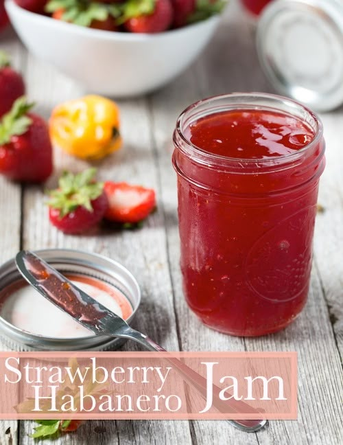 strawberry habanero jam in a mason jar on a wooden table with strawberries