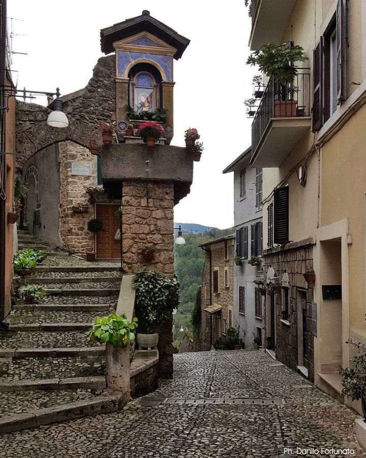 an old cobblestone street with stairs leading up to buildings